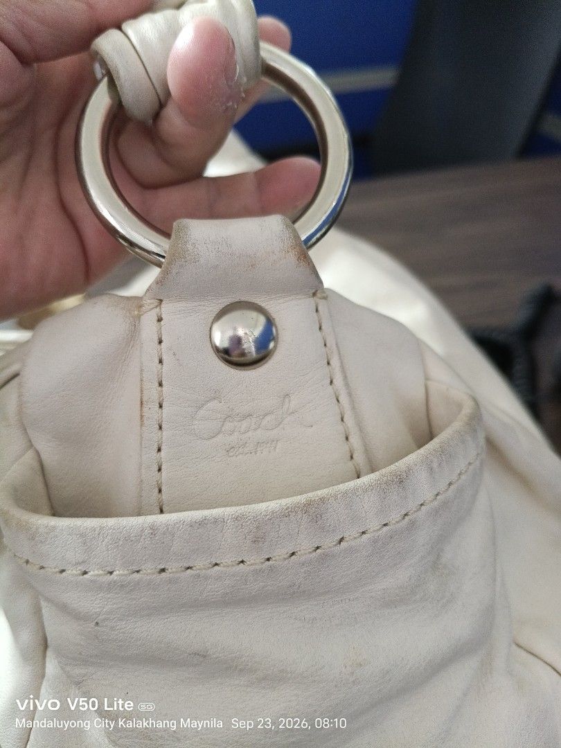 Coach Leather Hobo Handbag (Category: Luxury Bags & Wallets) located in Manila. Submitted by prettylook48762 (Listing ID 1463557686, Image 3). Description: - Cream colored Coach leather hobo bag - Soft leather with a stylish knotted strap detail - Secure zipper closure - Convenient interior pockets - Includes original Coach hangtag - Minor signs of wear on leather and edges, adding character - Interior is clean and well-maintained.