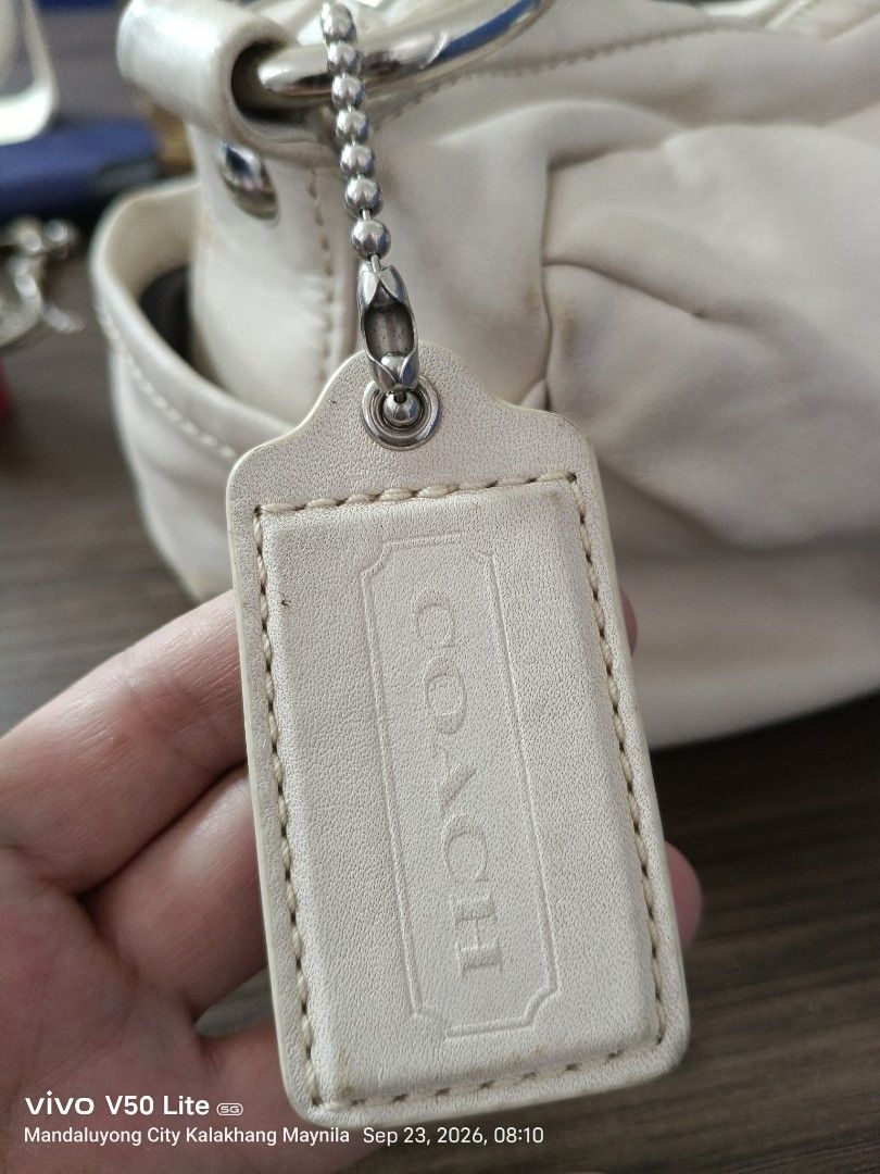 Coach Leather Hobo Handbag (Category: Luxury Bags & Wallets) located in Manila. Submitted by prettylook48762 (Listing ID 1463557686, Image 2). Description: - Cream colored Coach leather hobo bag - Soft leather with a stylish knotted strap detail - Secure zipper closure - Convenient interior pockets - Includes original Coach hangtag - Minor signs of wear on leather and edges, adding character - Interior is clean and well-maintained.