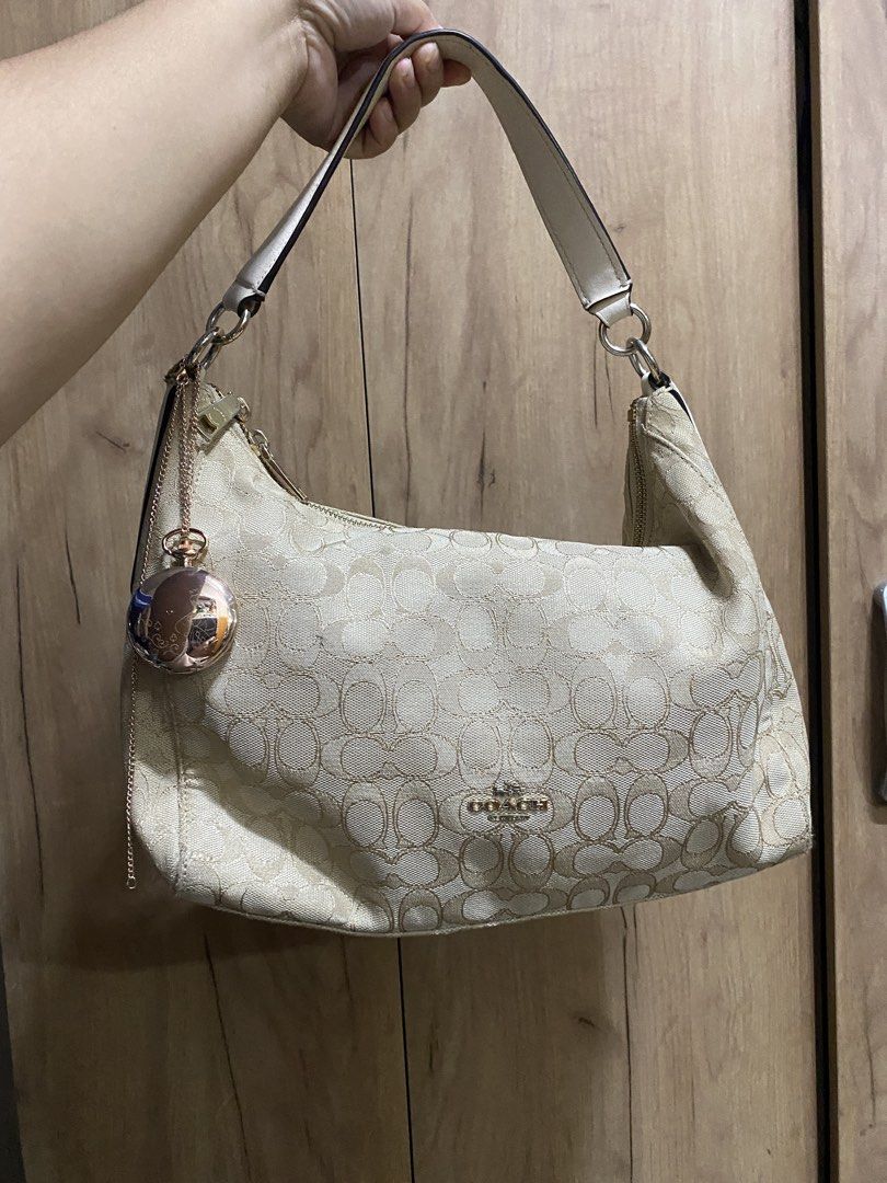 Coach Monogram Shoulder Bag with Charm (Category: Luxury Bags & Wallets) located in Manila. Submitted by cdb_22 (Listing ID 1463739466, Image 1). Description: - Classic Coach monogram shoulder bag - Beige and gold colorway - Adorable rose gold charm included - Secure zipper closure - Interior serial number tag (J1757-F58394) - Ideal for everyday use.