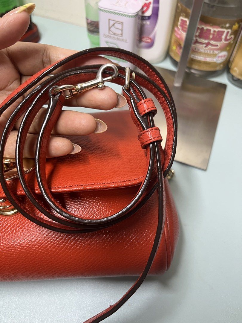 Coach Ruby in Orange Pebbled Leather Crossbody Bag with Chain Strap (Category: Cross-body Bags) located in Liloan. Submitted by sakurumifinds2809 (Listing ID 1463720764, Image 3). Description: - Coach orange pebbled leather crossbody bag -with care card and leather sling - Gold-tone hardware - Secure turn-lock closure - Detachable leather strap included - Detachable gold chain strap included - Comes with care instructions card - Versatile for eve