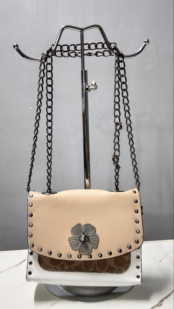 Coach Studded Flower Chain Bag (Category: Luxury Bags & Wallets) located in Manila. Submitted by faye_preloved (Listing ID 1463650758, Image 1). Description: - Adorable crossbody bag with signature Coach monogram print. - Features a charming flower detail on the front. - Stylish studded trim encircles the bag. - Convenient chain strap for easy carrying. - Versatile design, ideal for both casual outings and evening events..