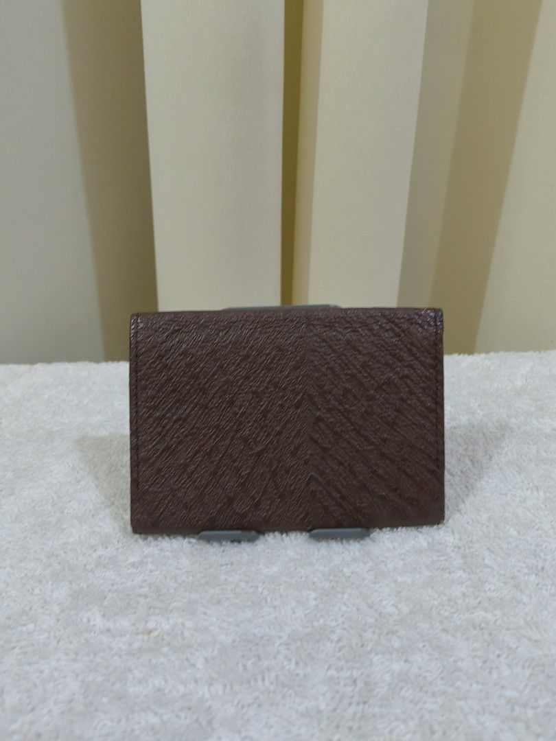 DE CHIRICO Brown Textured Card Holder (Category: Wallets & Card holders) located in Makati City. Submitted by prelovedtreatedwithlove (Listing ID 1463739299, Image 1). Description: - Brand: DE CHIRICO - Color: Brown - Material: Textured exterior - Features: Interior card slots - Design: Simple and classic - Functionality: Ideal for organizing business cards - Portability: Fits easily in pockets or small bags - No issue .