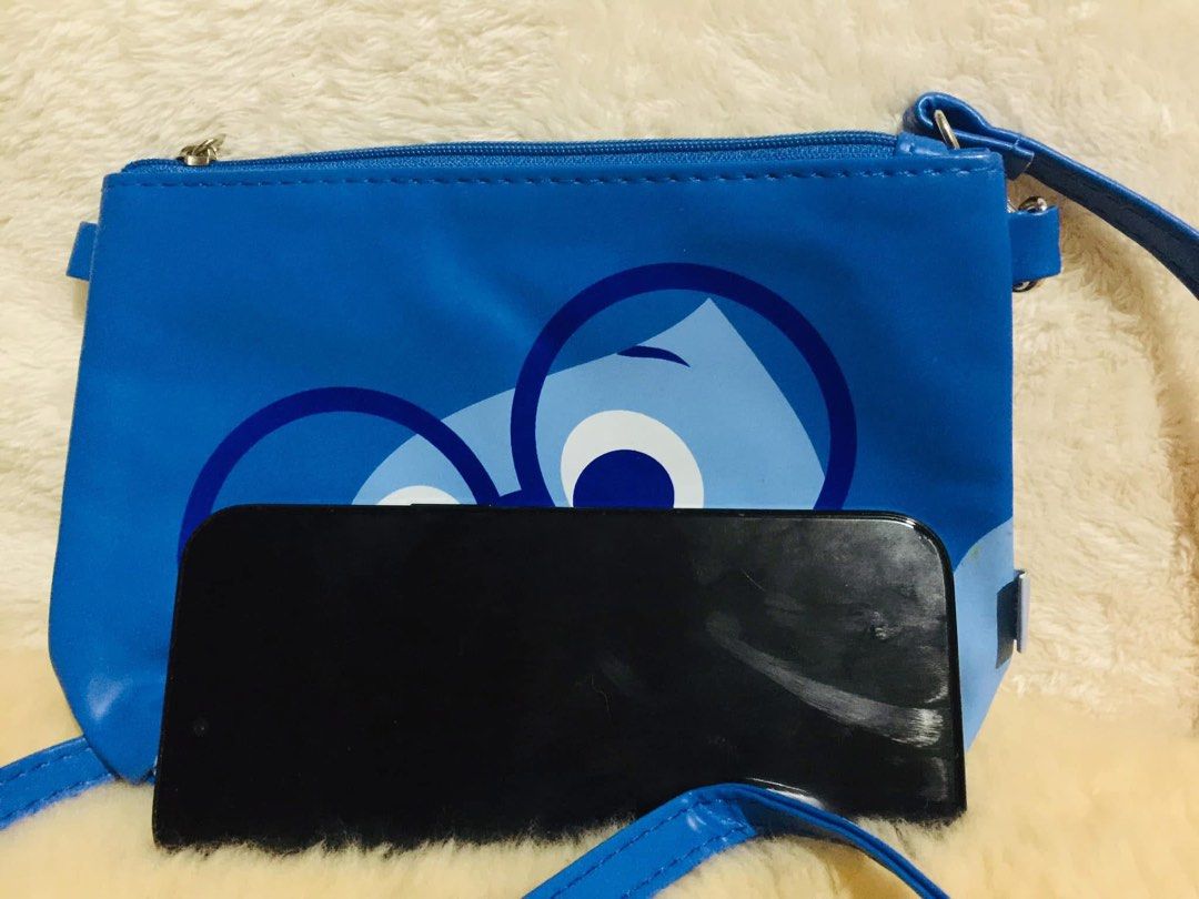 Disney Pixar Inside Out Sadness Blue Pouch Bag (Category: Purses & Pouches) located in Baguio. Submitted by izza_thrifty (Listing ID 1463664845, Image 2). Description: - Adorable blue pouch featuring Sadness from Disney's Inside Out. - Secure zipper closure to keep your items safe. - Comes with a convenient detachable strap. - Features a clear plastic interior, perfect for organizing small essentials. - Size is comparable to a smartphone, making 
