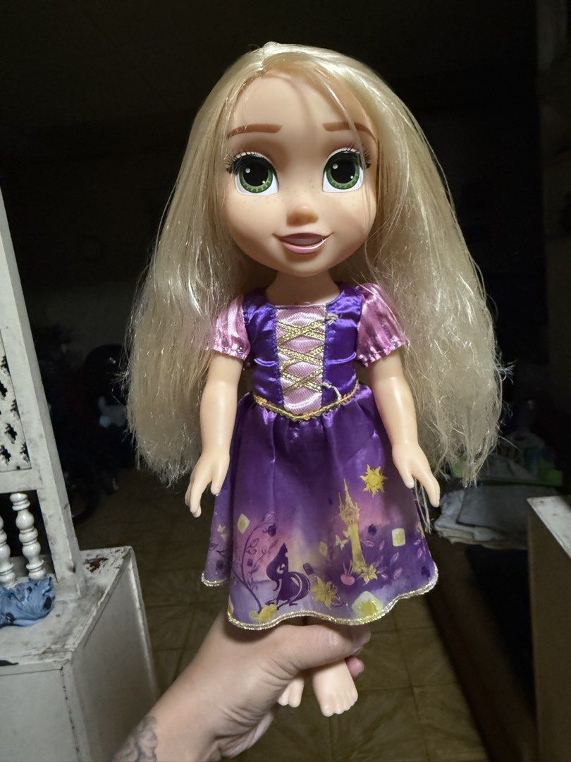 Disney Tangled Rapunzel Doll (Category: Figurines & Statues) located in Las Pinas. Submitted by yourboki.2026 (Listing ID 1463653819, Image 1). Description: - Authentic Rapunzel doll from Disney's Tangled - Features her iconic long blonde hair - Comes with her signature purple dress adorned with sparkly lantern designs - Hair is slightly tangled at the ends, easily fixable - A must-have for any fan of the beloved movie.