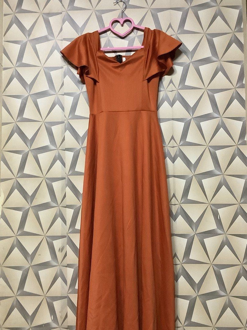 elegant burnt orange / rust evening gown (Category: Evening dresses & gowns) located in Quezon City. Submitted by lovedbyerara (Listing ID 1463692175, Image 1). Description: Silhouette: Classic A-line style with a fitted high-waist band that flows into a floor-length flared skirt. Neckline & Bodice: A square/scoop neckline paired with structured vertical bodice seams to create a tailored, form-fitting look. Sleeves: Playful and feminine flutter s