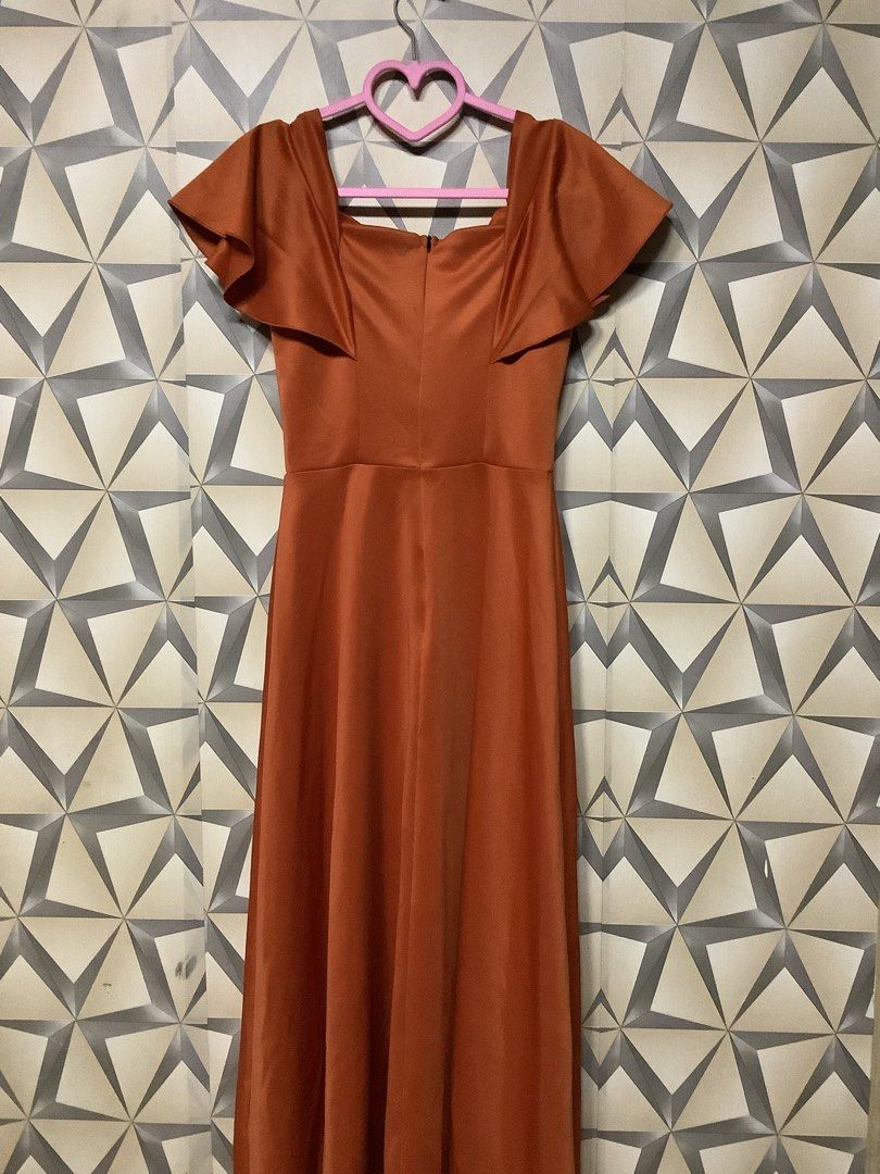 elegant burnt orange / rust evening gown (Category: Evening dresses & gowns) located in Quezon City. Submitted by lovedbyerara (Listing ID 1463692175, Image 3). Description: Silhouette: Classic A-line style with a fitted high-waist band that flows into a floor-length flared skirt. Neckline & Bodice: A square/scoop neckline paired with structured vertical bodice seams to create a tailored, form-fitting look. Sleeves: Playful and feminine flutter s