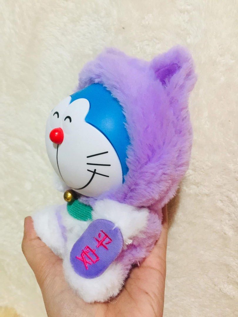 FUJIKO PRO Doraemon lucky cat (Category: Plushies & Soft Toys) located in Baguio. Submitted by izza_thrifty (Listing ID 1463671346, Image 2). Description: - Adorable Doraemon plush toy - Features a cute purple hoodie - Has a little bell around its neck - Super soft and cuddly material - Ideal gift for Doraemon enthusiasts - Approximately [Insert size here if known].