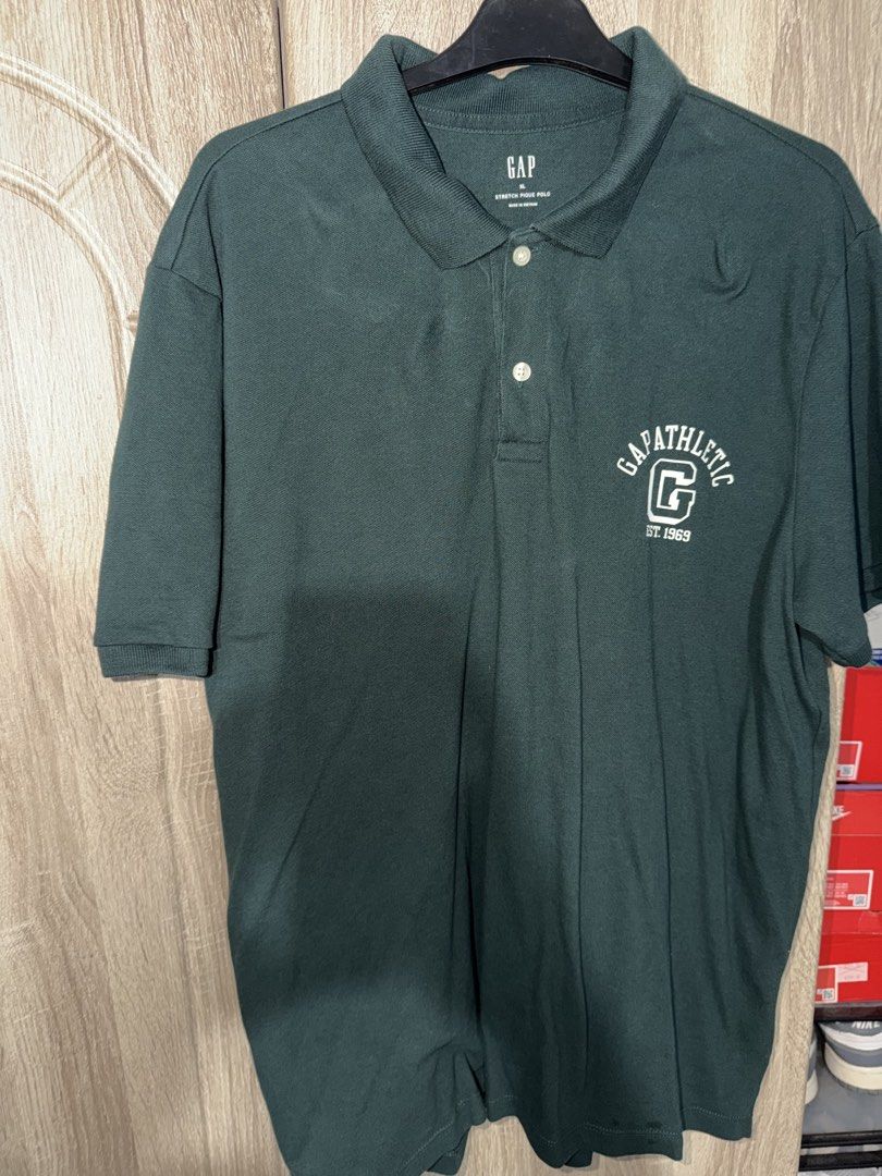GAP Men's Polo Shirts - Various Colors & Sizes (Category: Tshirts & Polo Shirts ) located in Manila. Submitted by marlboxspace (Listing ID 1463720425, Image 2). Description: - GAP Polo Shirt (Tan): Features navy and maroon stripes. - GAP Polo Shirt (Dark Green): Includes 'GAPATHLETIC' graphic. - Both shirts have a classic collared neckline and button closure. - Versatile for casual outings or slightly dressed-up occasions. 1000 each kept unused w