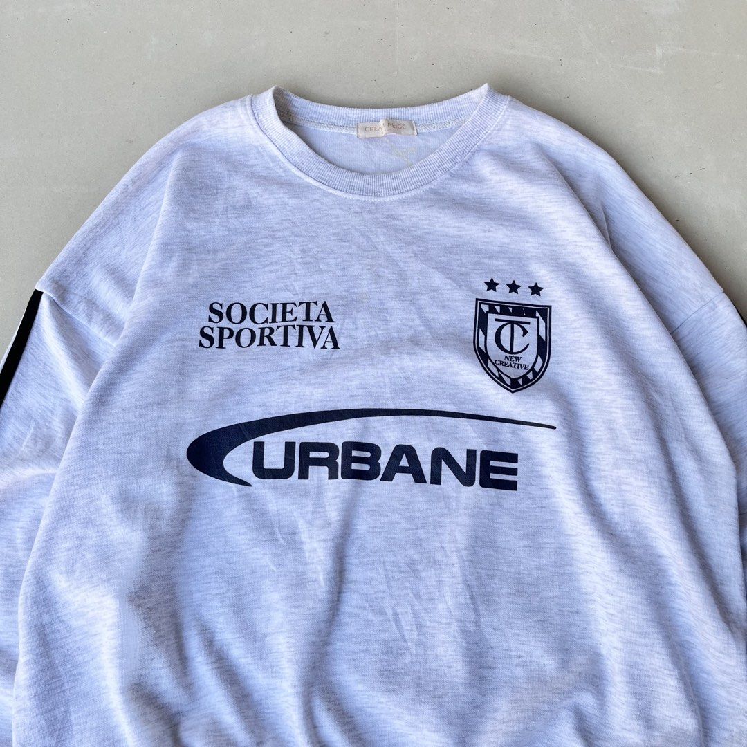 Grey "Urbane" Graphic Sweatshirt Size M (Category: Coats, Jackets and Outerwear) located in Mandaue City. Submitted by chinsyap_03 (Listing ID 1463630424, Image 2). Description: - Grey sweatshirt with 'Societa Sportiva' and 'Urbane' graphics - Features black stripes on the sleeves - Crew neck, long sleeves - Ribbed cuffs and hem - Made from soft, comfortable fabric - Ideal for casual wear.