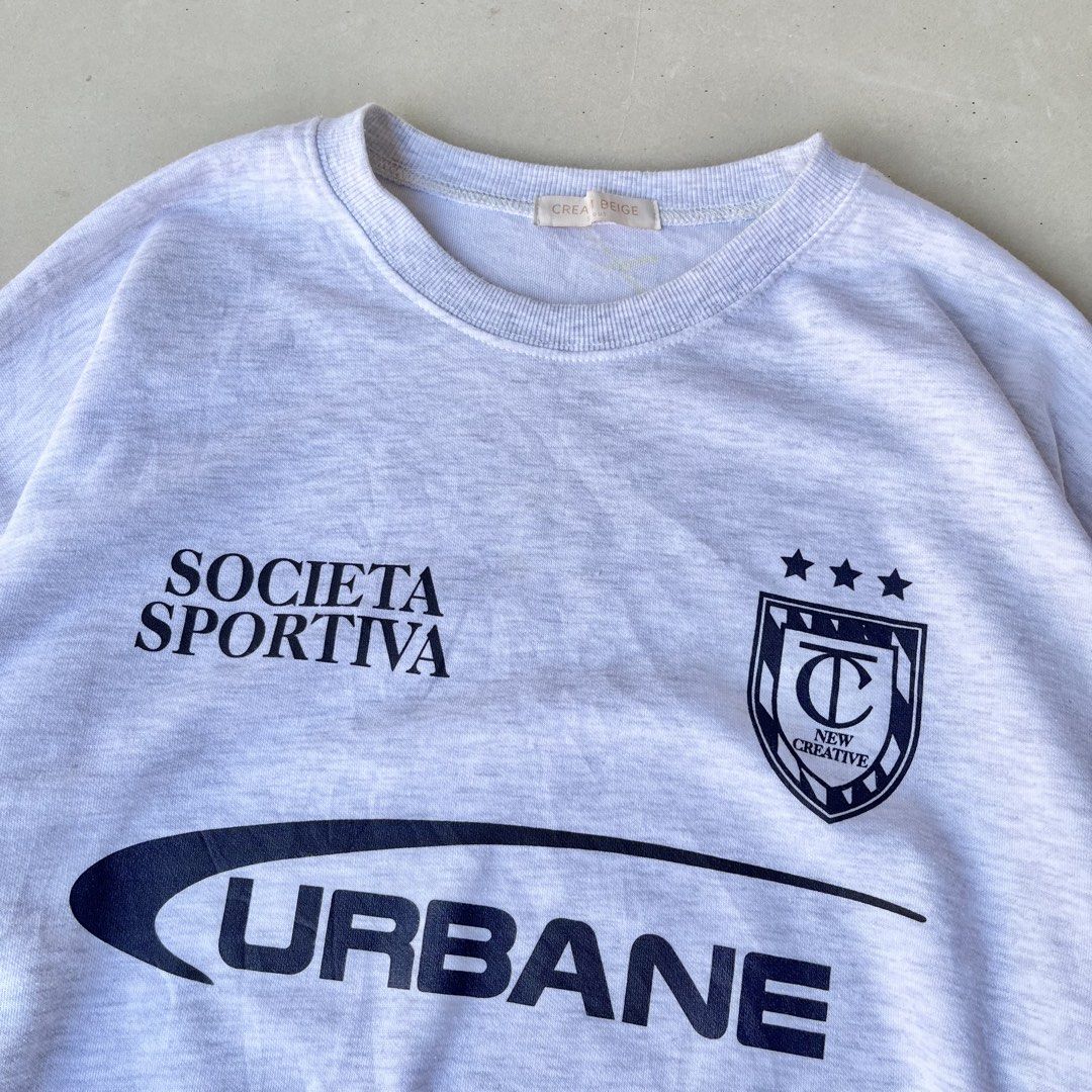 Grey "Urbane" Graphic Sweatshirt Size M (Category: Coats, Jackets and Outerwear) located in Mandaue City. Submitted by chinsyap_03 (Listing ID 1463630424, Image 3). Description: - Grey sweatshirt with 'Societa Sportiva' and 'Urbane' graphics - Features black stripes on the sleeves - Crew neck, long sleeves - Ribbed cuffs and hem - Made from soft, comfortable fabric - Ideal for casual wear.