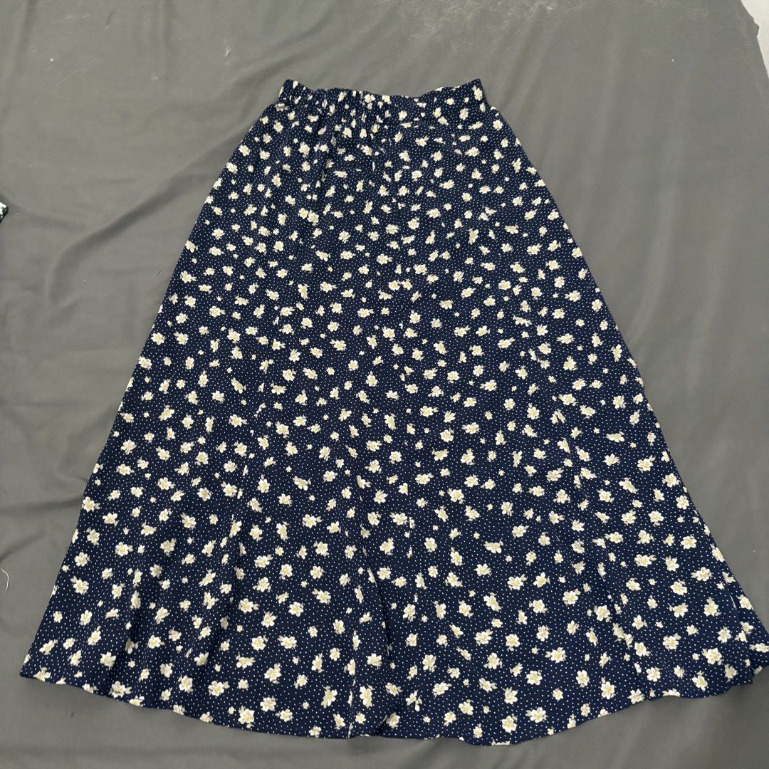 GU Navy Floral Midi Skirt (Category: Skirts) located in Makati City. Submitted by sseurekiii (Listing ID 1463721390, Image 1). Description: - Navy blue midi skirt - White and yellow floral print - Scattered white polka dots - Comfortable elastic waistband - Flowy A-line silhouette - Versatile for casual or dressed-up looks.