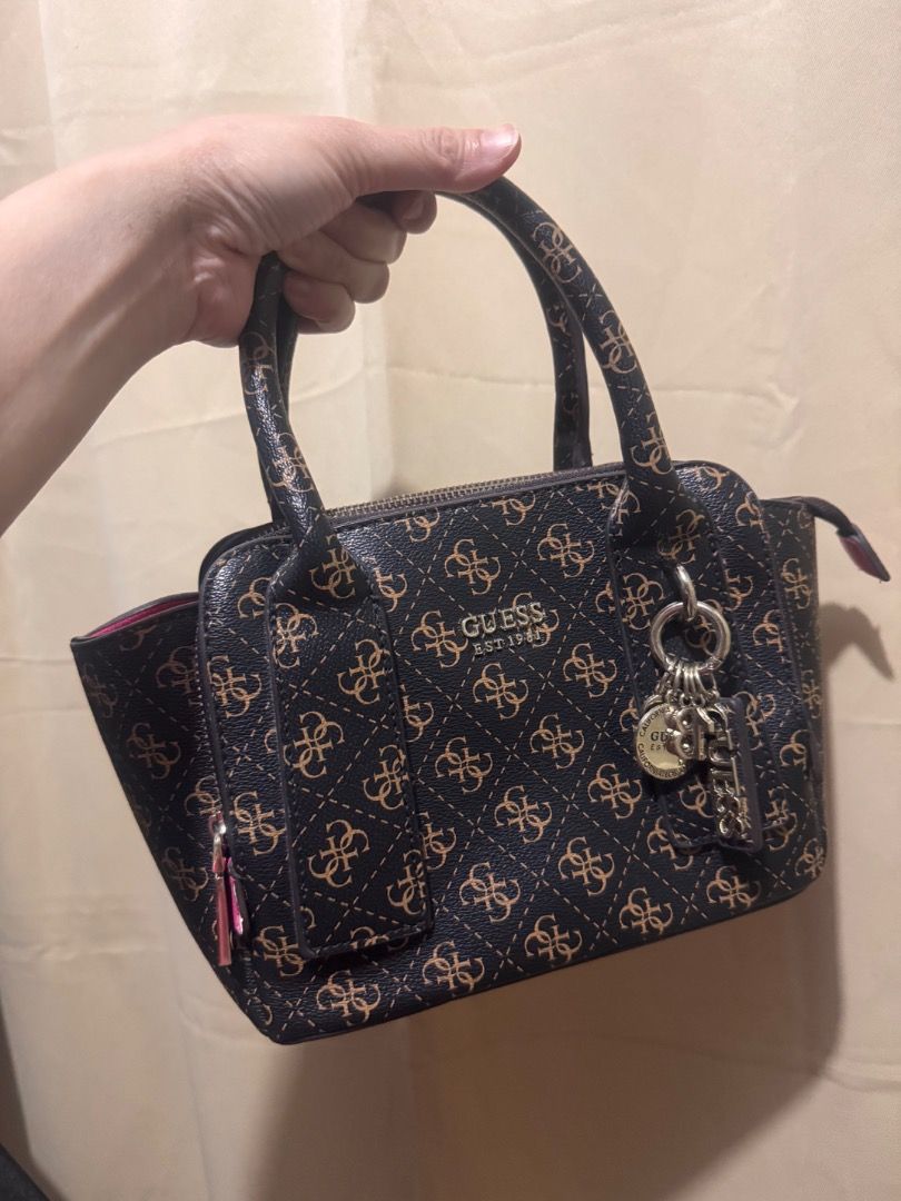 Authentic Guess Monogram Satchel Bag (Category: Shoulder Bags) located in Imus. Submitted by jazzmin04 (Listing ID 1463703766, Image 1). Description: - Stylish Guess monogram satchel bag in brown and tan. - Eye-catching bright pink interior with multiple compartments for organization. - Comes with a detachable shoulder strap for versatile carrying options. - Ideal everyday bag for your essentials. - Clean inside - Overall perfect bag but Pink par