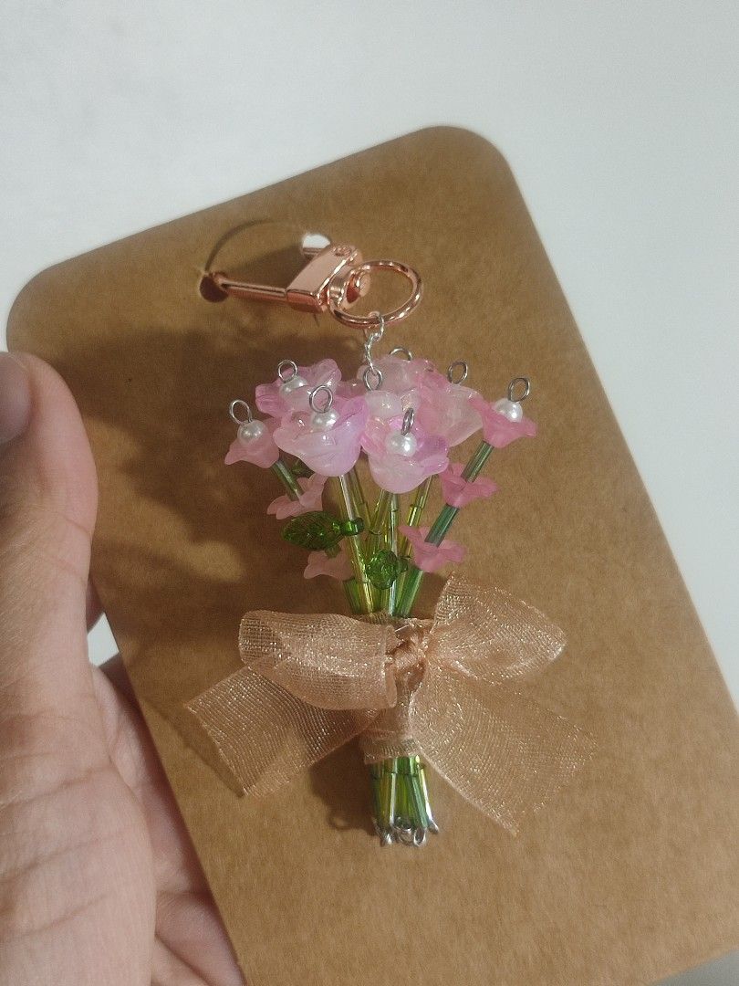Handmade Beaded Flower Bouquet Keychain (Category: Handmade Craft) located in Manila. Submitted by messiscar290860 (Listing ID 1463556381, Image 1). Description: - Adorable handmade keychain with a beaded flower bouquet. - Finished with a delicate sheer ribbon and a stylish rose gold clasp. - A unique and charming accessory for your bag, backpack, or as a thoughtful gift..