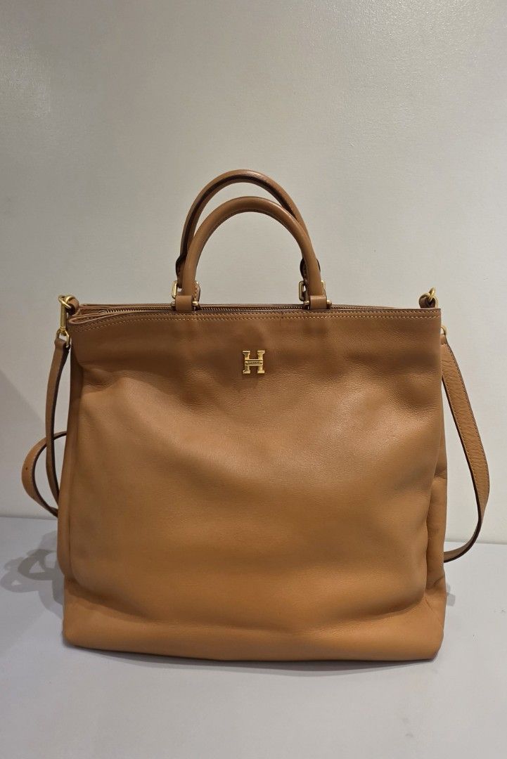 Hazzys Leather Tote Bag Tan Gold Hardware (Category: Tote Bags) located in Manila. Submitted by amc88 (Listing ID 1463612002, Image 1). Description: - Genuine tan leather tote bag by Hazzys - Elegant gold hardware and signature 'H' logo - Interior features branded lining and a secure zippered compartment - Comes with a detachable shoulder strap for versatile carrying - Spacious design, ideal for your daily essentials - Barely noticeable signs of 