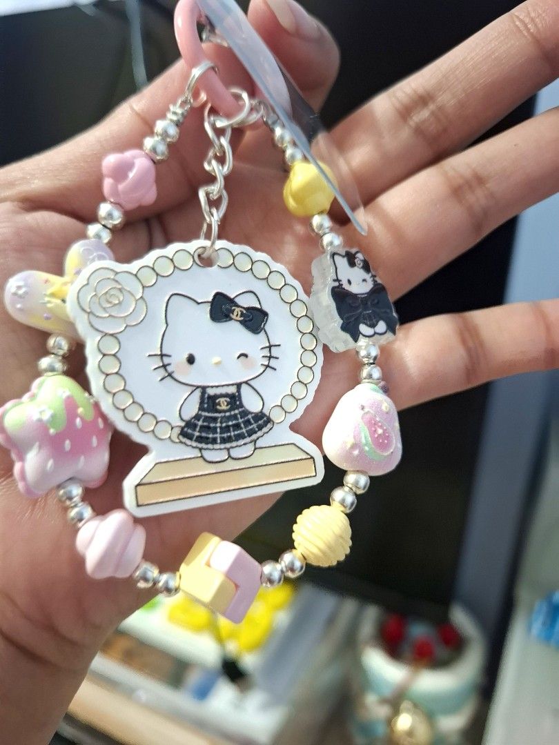 Pink Hello Kitty Charm Phone Wrist Keychain (Category: Charms) located in Quezon City. Submitted by an.marie (Listing ID 1463633199, Image 3). Description: Super cute Kitty keychain with a Chanel-inspired outfit charm. Adorned with colorful beads (strawberries, macarons, pearls) and a pink ring/chain. Perfect for phone, bags or keys!.