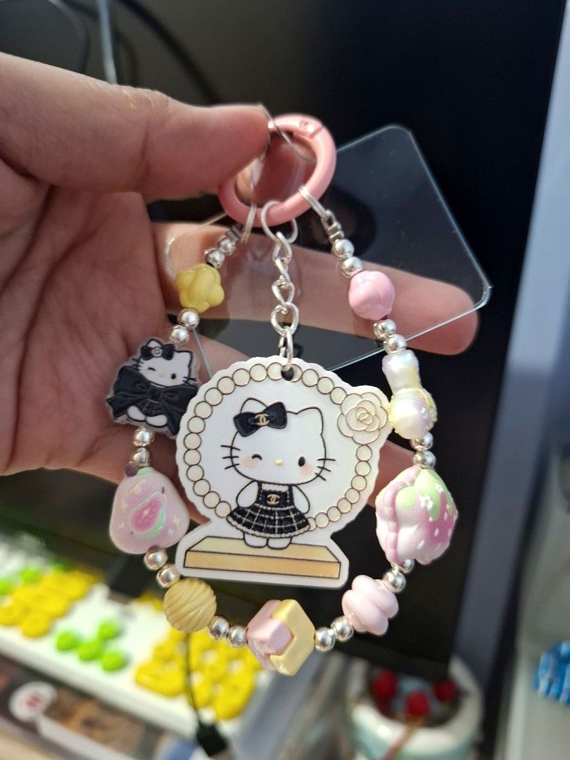 Pink Hello Kitty Charm Phone Wrist Keychain (Category: Charms) located in Quezon City. Submitted by an.marie (Listing ID 1463633199, Image 1). Description: Super cute Kitty keychain with a Chanel-inspired outfit charm. Adorned with colorful beads (strawberries, macarons, pearls) and a pink ring/chain. Perfect for phone, bags or keys!.