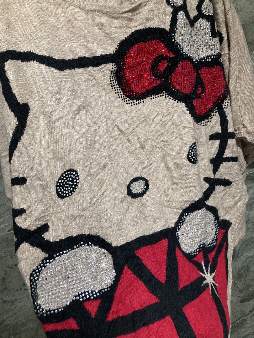 Hello kitty Knitted blouse (free shipping) (Category: Blouses) located in General Santos City (Dadiangas). Submitted by amorhesthrift (Listing ID 1463703120, Image 2). Description: The image shows a beige, short-sleeved knit top featuring a large Hello Kitty graphic with a sparkling red bow, a crown, and holding a red gem. Size-XL.