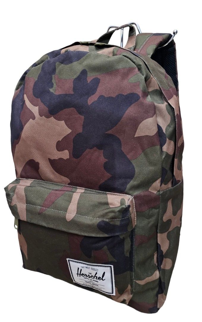 Herschel Camo Backpack 12x17x4.5 inches (Category: Backpacks) located in Pasig City. Submitted by chichirepublic (Listing ID 1463669719, Image 2). Description: - Classic Herschel backpack in a cool camouflage print. - Dimensions: Approx. 12" wide, 17" tall, 4.5" deep. - Features a convenient front pocket with a zipper. - Signature Herschel logo patch on the front. - Padded shoulder straps for maximum comfort. - Ideal for school, work, or everyday