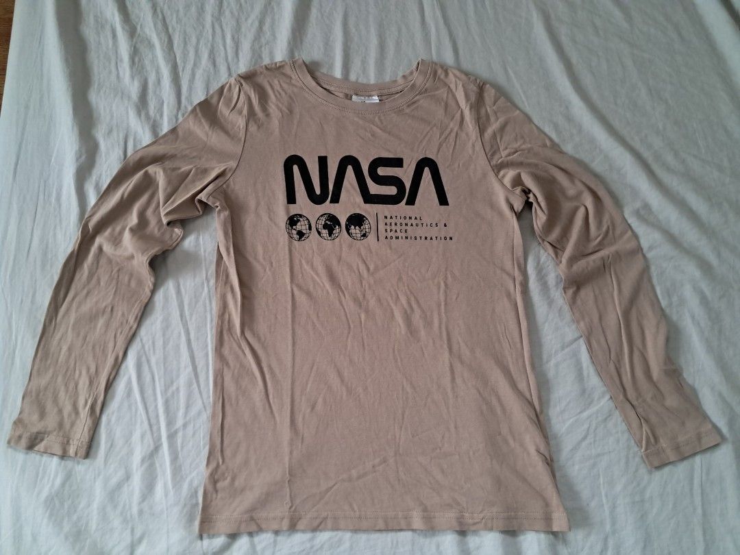 H&M Pajama Set (Category: Babies & Kids Fashion) located in Valenzuela. Submitted by famsbest (Listing ID 1463685262, Image 2). Description: - Beige H&M long sleeve t-shirt with NASA graphic print - Black joggers appear to be brownish but just the camera shot. It's all black in person. - T-shirt size: 10-12 Years - Pants size: Suitable for similar age range - Loungewear.