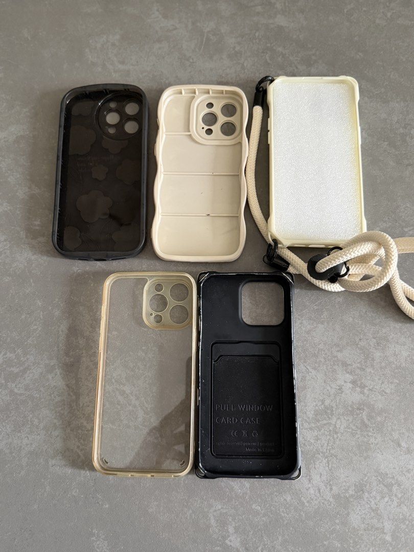 iPhone 15Pro Max Cases Bundle – 5 Cases + Crossbody Case (Category: Cases & Sleeves) located in Taytay. Submitted by thestyletwins (Listing ID 1463603682, Image 3). Description: iPhone Cases Bundle – 5 Cases + Crossbody Case Selling as a bundle of 5 preloved iPhone cases in neutral black, cream and clear designs. Includes: * Black floral case * Cream wavy-edge case * Cream case with detachable crossbody/shoulder strap * Clear case with beige trim