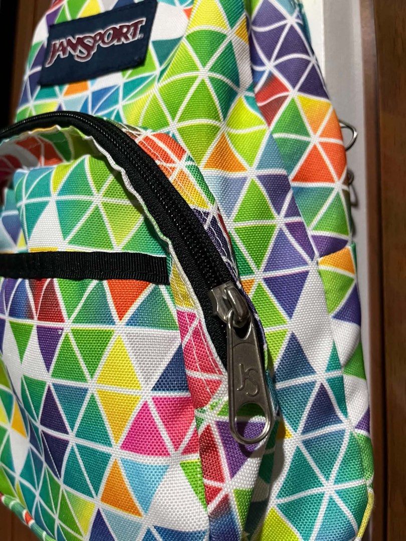Jansport Backpack - Colorful Geometric Print (Category: Backpacks) located in Quezon City. Submitted by bentot24 (Listing ID 1463695109, Image 2). Description: - Vibrant geometric triangle print Jansport backpack - Main compartment for storage - Front zip pocket for essentials - Adjustable black straps for comfort - Perfect for school or daily use - Zippers work smoothly - Clean inside and out.