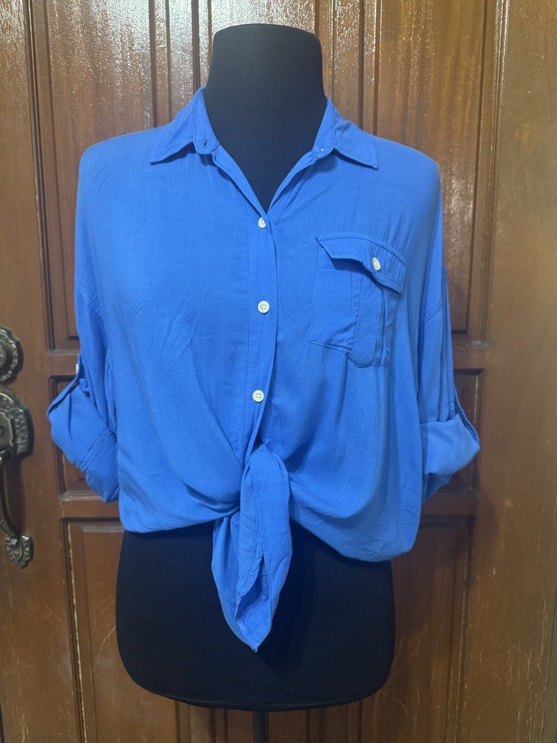 Just G Vive La Rock Blue Button Up Shirt (Category: Longsleeves) located in Manila. Submitted by prelovedshopmnl (Listing ID 1463579796, Image 3). Description: - Blue button-up shirt by Just G - Left chest pocket - Sleeves can be rolled up and secured with a button - Can be tied at the front for a cropped look - Ideal for casual wear.