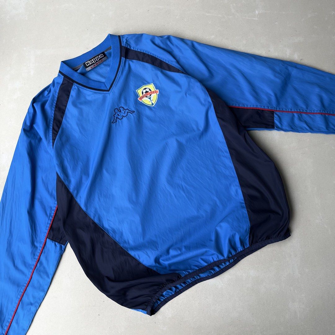 Kappa Blue Windbreaker Jacket Size L (Category: Coats, Jackets and Outerwear) located in Mandaue City. Submitted by chinsyap_03 (Listing ID 1463652683, Image 2). Description: - Blue Kappa windbreaker jacket - Size: Large (L) - Kappa logo prominently displayed on front and back - Stylish dark blue side and shoulder panels - Elasticated cuffs and hem for a comfortable fit - Ideal for both athletic activities and everyday casual wear.