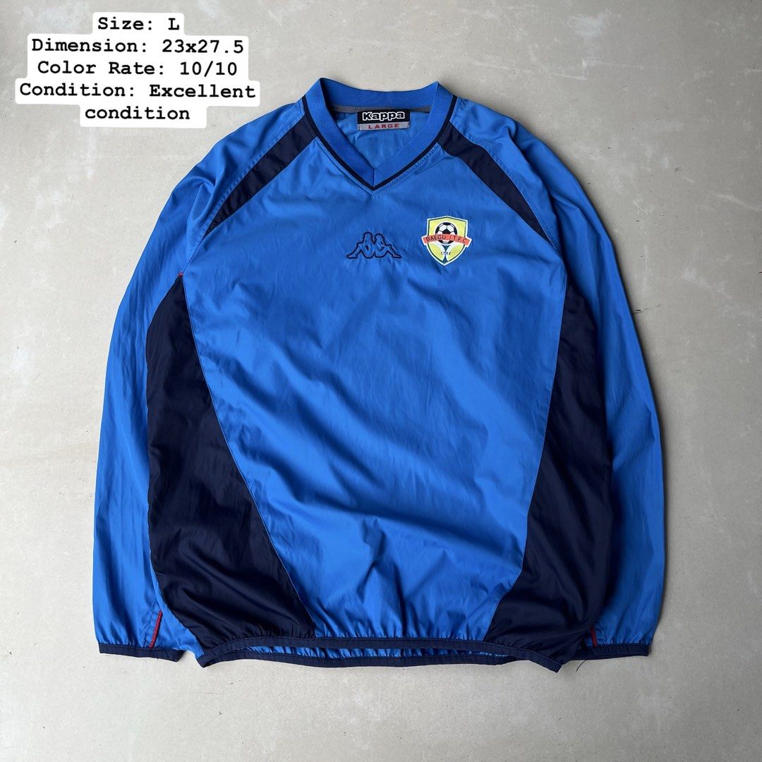 Kappa Blue Windbreaker Jacket Size L (Category: Coats, Jackets and Outerwear) located in Mandaue City. Submitted by chinsyap_03 (Listing ID 1463652683, Image 1). Description: - Blue Kappa windbreaker jacket - Size: Large (L) - Kappa logo prominently displayed on front and back - Stylish dark blue side and shoulder panels - Elasticated cuffs and hem for a comfortable fit - Ideal for both athletic activities and everyday casual wear.