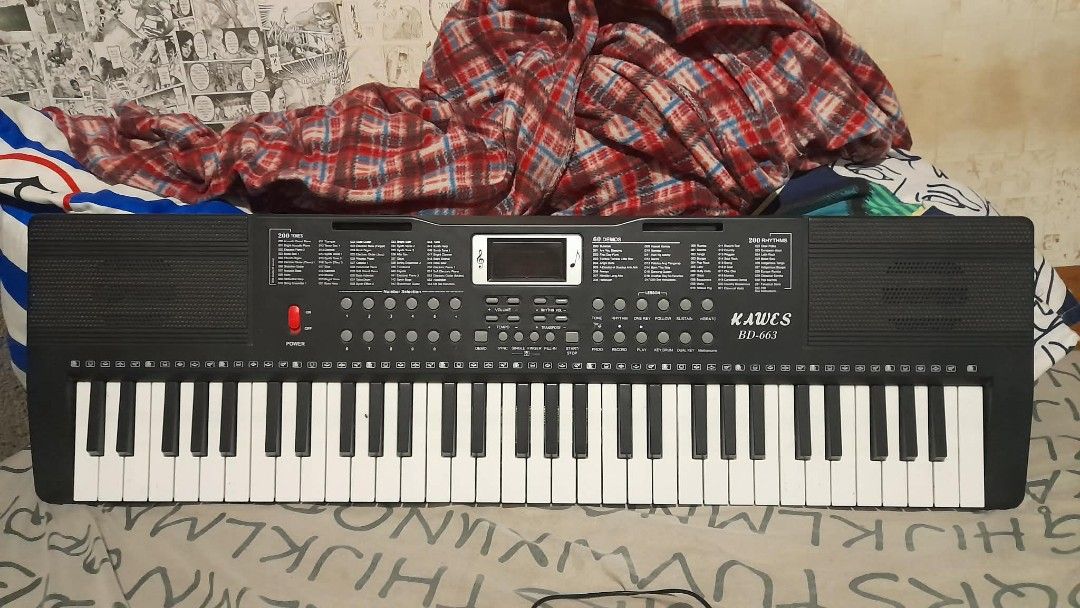 KAWCS BD-663 Electronic Keyboard Piano (Category: Musical Instruments) located in Manila. Submitted by axolotlelele (Listing ID 1463721200, Image 1). Description: - KAWCS BD-663 Electronic Keyboard - 61 Keys - Wide variety of instrument sounds and rhythms - Includes demo songs for learning and practice - Features a red power button - Central screen displays information - Built-in speakers on top.