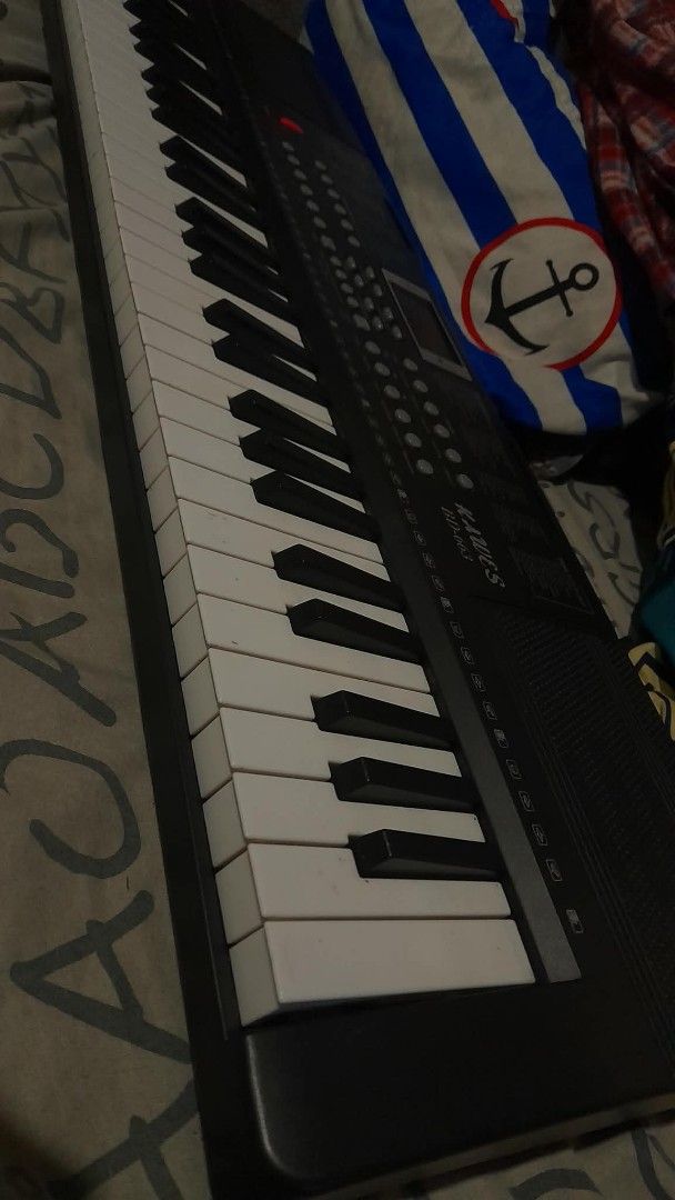 KAWCS BD-663 Electronic Keyboard Piano (Category: Musical Instruments) located in Manila. Submitted by axolotlelele (Listing ID 1463721200, Image 2). Description: - KAWCS BD-663 Electronic Keyboard - 61 Keys - Wide variety of instrument sounds and rhythms - Includes demo songs for learning and practice - Features a red power button - Central screen displays information - Built-in speakers on top.