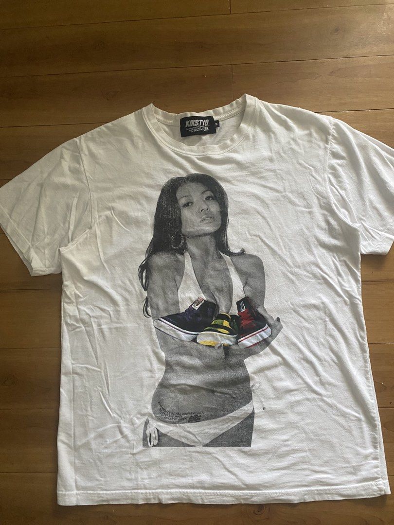 KIKSTYO Graphic T-Shirt Size M (Category: Tshirts & Polo Shirts ) located in Caloocan City. Submitted by NotYetDressed (Listing ID 1463716845, Image 1). Description: - White KIKSTYO graphic t-shirt - Size: Medium (M) - Front graphic: Woman holding sneakers - Back graphic: Minimalist shoe design - Ideal for sneaker enthusiasts.