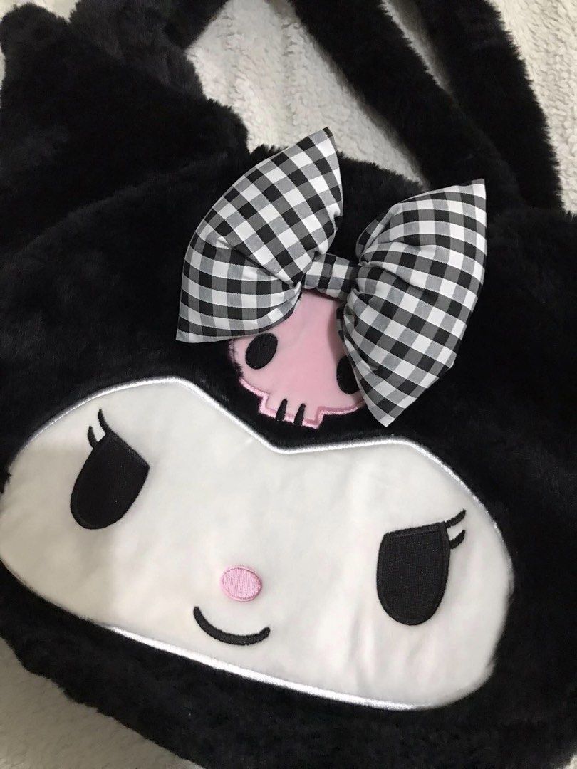 Kuromi Plush Tote Bag with Gingham Bow (Category: Plushies & Soft Toys) located in Manila. Submitted by hearthearty (Listing ID 1463690629, Image 2). Description: - Super cute Kuromi plush tote bag - Made of soft, fuzzy black material - Features Kuromi's face on the front - Adorned with a black and white gingham bow - Fuzzy handles for comfortable carrying - Ideal for storing essentials in style - A must-have for any Sanrio fan!.
