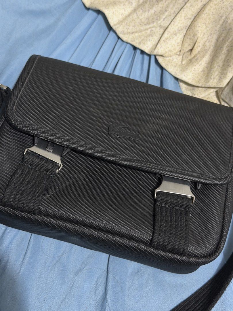 Lacoste Black Messenger Bag (Category: Sling Bags) located in Manila. Submitted by hammiedos (Listing ID 1463711624, Image 1). Description: Selling my pre owned bag. This is original Rfs change bag Kayo na pa clean sa bag sa harap then may scratch lang sa buckle , tngan nyo na lang po pic Location pcampa - Authentic Lacoste black messenger bag - Made from durable material - Secure flap closure with stylish metal buckles - Adjustable strap for com