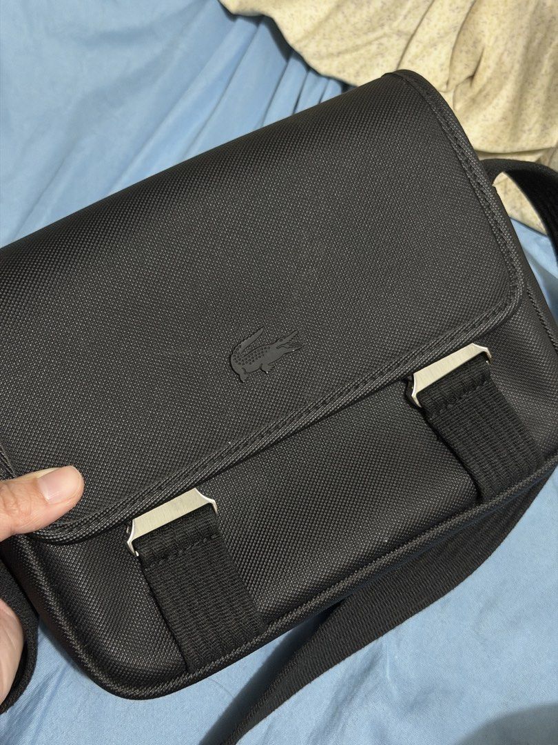 Lacoste Black Messenger Bag (Category: Sling Bags) located in Manila. Submitted by hammiedos (Listing ID 1463711624, Image 2). Description: Selling my pre owned bag. This is original Rfs change bag Kayo na pa clean sa bag sa harap then may scratch lang sa buckle , tngan nyo na lang po pic Location pcampa - Authentic Lacoste black messenger bag - Made from durable material - Secure flap closure with stylish metal buckles - Adjustable strap for com