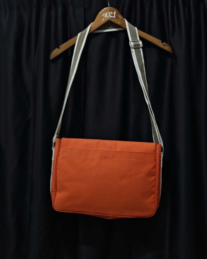 Lacoste Orange Messenger Bag (Category: Sling Bags) located in Baguio. Submitted by solo_ukay (Listing ID 1463694229, Image 2). Description: - Vibrant orange Lacoste messenger bag - Spacious main compartment with interior zip pocket - Front flap with secure velcro closure - Multiple internal pockets for organization - Adjustable strap for comfortable carrying - Ideal for everyday errands or travel adventures.
