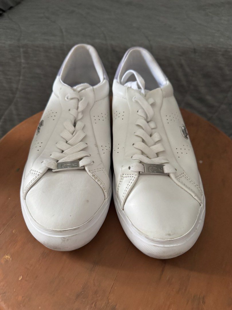 Lacoste White Leather Sneakers (Category: Sneakers) located in Las Pinas. Submitted by megalleon8 (Listing ID 1463682513, Image 1). Description: - White leather Lacoste sneakers - Size: 6 US Women's - Perforated details on the sides - Subtle purple accent on the heel - Ideal for casual wear.