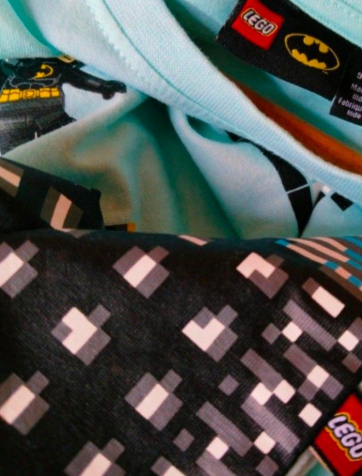LEGO Batman T-shirt (Category: Babies & Kids Fashion) located in Pasig City. Submitted by babylove2003 (Listing ID 1463570220, Image 2). Description: Light blue t-shirt with a cool LEGO Batman graphic. Features a pixelated cityscape and Batman flying. Made by KABOOKI under license from The LEGO Group. Tag says size 140. Great for any young Batman fan who loves LEGO!.