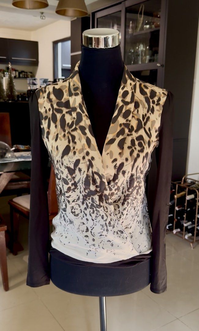Leopard Print Wrap Blouse with Black Sleeves (Category: Blouses) located in Manila. Submitted by timelessfindsbyjoann (Listing ID 1463712864, Image 1). Description: - Stylish wrap blouse - Bold leopard print front - Contrasting long black sleeves - Flattering cowl neckline - Versatile for dressing up or down - Pairs well with jeans or trousers.