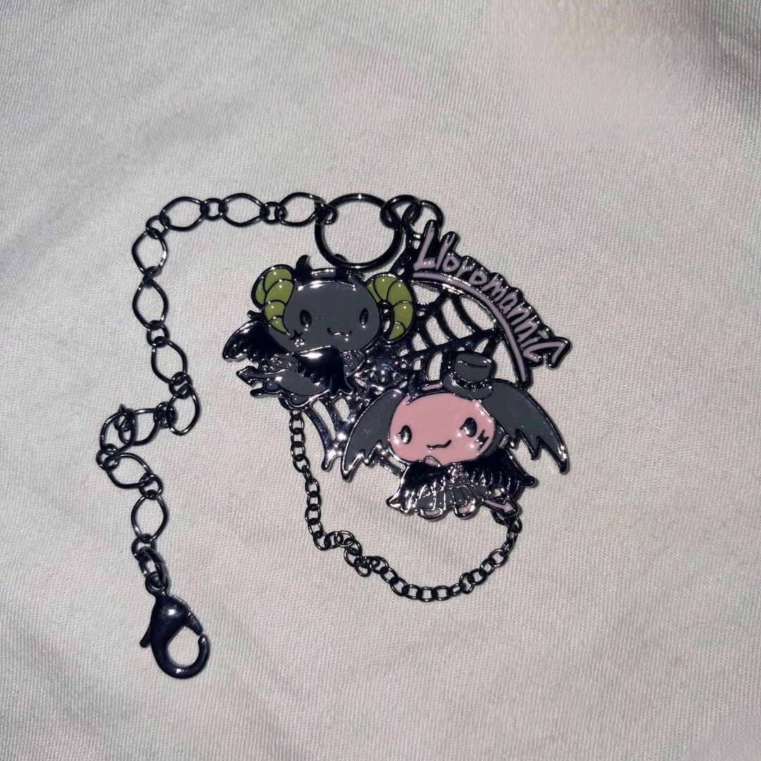 Lloromannic Charm (Category: Character Goods) located in Valenzuela. Submitted by sell.buy.acc (Listing ID 1463702878, Image 1). Description: - Adorable pink bat and grey ram charm - Features a cool spiderweb design - 'Lloromanic' text detail - Sturdy lobster clasp for easy attachment - Perfect for decorating bags, backpacks, or keys - Adds a fun, gothic flair to your accessories.