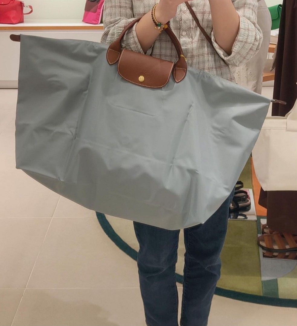 Longchamp Le Pliage Travel Bag (Category: Luxury Bags & Wallets) located in Paoay. Submitted by rvf1230 (Listing ID 1463678294, Image 2). Description: - Light grey Longchamp tote bag - Durable nylon material with leather handles and trim - Secure zipper closure with snap tab - Spacious interior for all your essentials - Folds flat for convenient storage - Ideal for travel or everyday use - A classic and practical accessory.