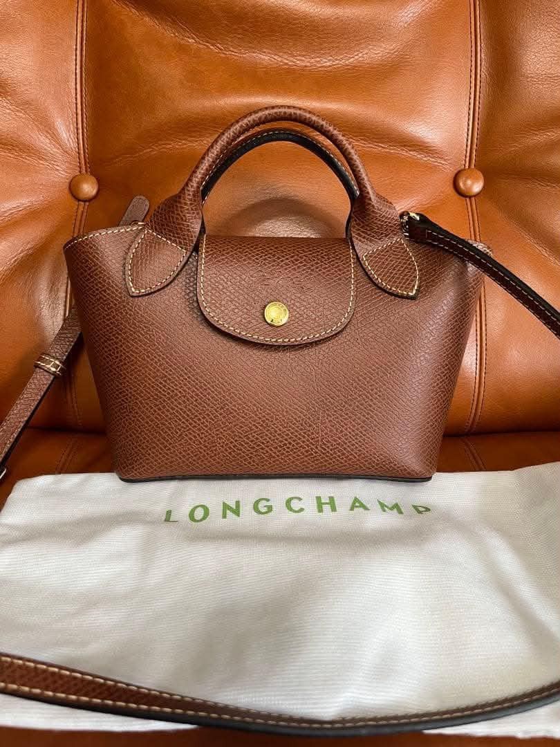 Longchamp Top Handle Bag (Category: Luxury Bags & Wallets) located in Paoay. Submitted by rvf1230 (Listing ID 1463678152, Image 3). Description: - Authentic Longchamp handbag - Small size, ideal for essentials - Rich brown textured leather - Top handles and detachable shoulder strap - Elegant gold hardware details - Comes with original dust bag - Versatile for daily use or special occasions.