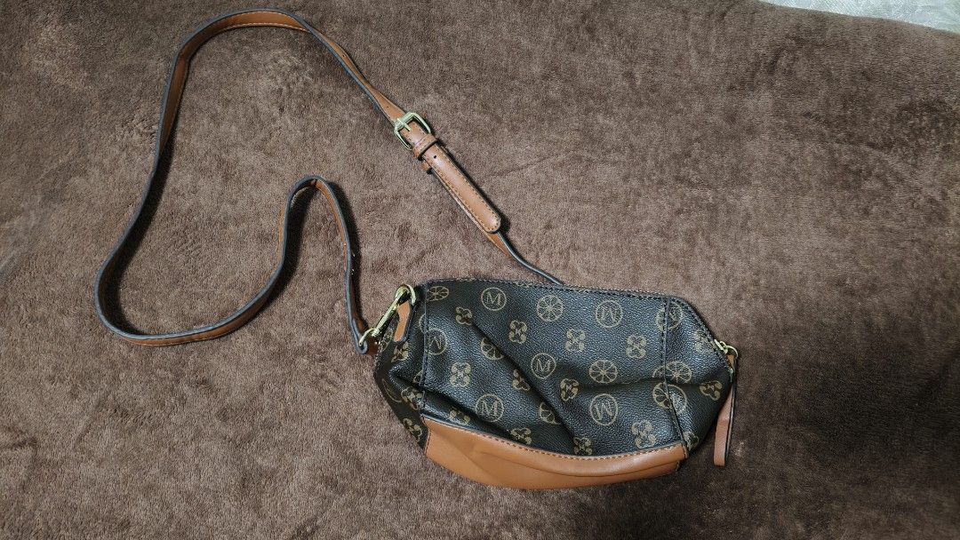 LOUIS DEYA Monogram Crossbody Bag Brown (Category: Luxury Bags & Wallets) located in Manila. Submitted by serenitycarlylle (Listing ID 1463723423, Image 1). Description: - Stylish brown crossbody bag with Louis Deya monogram print. - Accented with tan leather trim and strap. - Secure zipper closure for your belongings. - Interior zippered pocket for organization. - Elegant gold hardware details. - Adjustable strap for a comfortable fit..