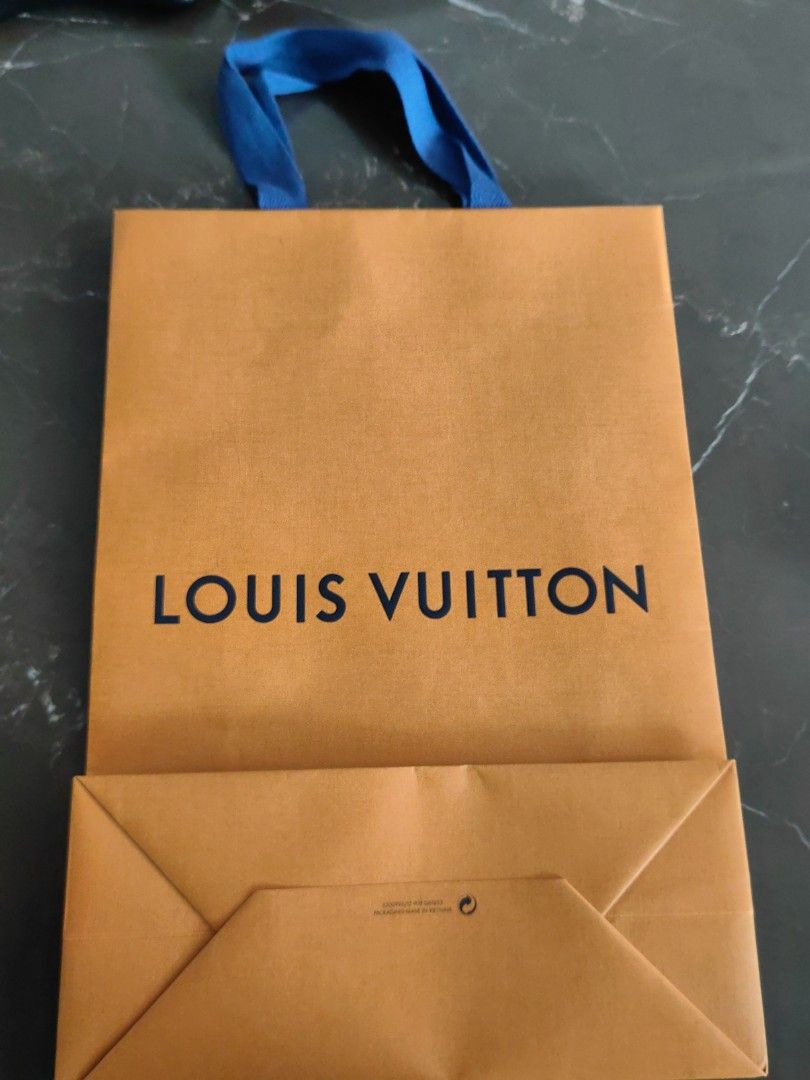 Louis Vuitton Shopping Bag (Category: Luxury Accessories) located in Makati City. Submitted by kruelscloset (Listing ID 1463603304, Image 2). Description: - Authentic Louis Vuitton paper shopping bag - Color: Orange with blue ribbon handles - "Maison Fondee En 1854 Paris" detail - Made in Vietnam - Approximate dimensions: 25cm (width) x 36cm (height) - Ideal for gifting or storing small items.