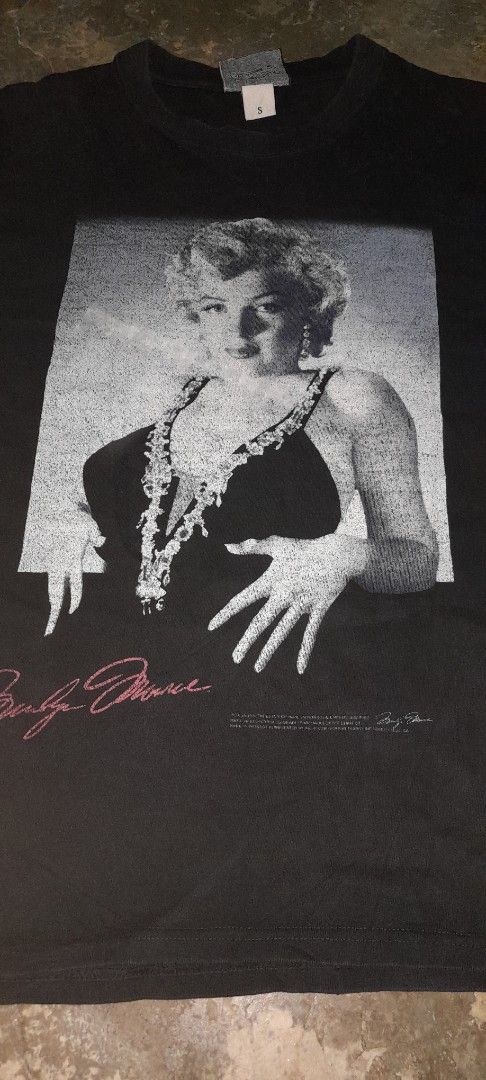 Marilyn Monroe Graphic T-Shirt (Category: Shirts) located in Manila. Submitted by goldrugs (Listing ID 1463570908, Image 2). Description: - Classic black t-shirt - Features a striking Marilyn Monroe graphic print - Includes Marilyn's signature and text details - Unique doodle design on the tag - Approximate measurements: 20 inches wide x 27.5 inches long - Ideal for fans of the iconic Marilyn Monroe.