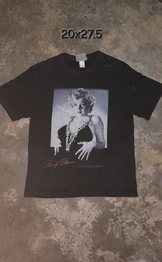 Marilyn Monroe Graphic T-Shirt (Category: Shirts) located in Manila. Submitted by goldrugs (Listing ID 1463570908, Image 1). Description: - Classic black t-shirt - Features a striking Marilyn Monroe graphic print - Includes Marilyn's signature and text details - Unique doodle design on the tag - Approximate measurements: 20 inches wide x 27.5 inches long - Ideal for fans of the iconic Marilyn Monroe.
