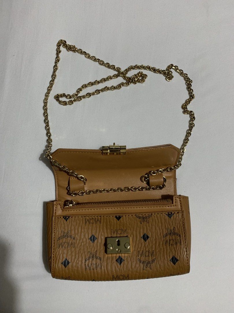 MCM Cognac Visetos wallet Bag on Chain (Category: Luxury Bags & Wallets) located in Cavite. Submitted by honeyjmo (Listing ID 1463595437, Image 2). Description: - Authentic MCM clutch bag - Classic Visetos monogram print - Gold hardware - Detachable gold chain strap - Interior zip pocket - Perfect for carrying your essentials - No inclusions- bag only - Gift - For self authentication.
