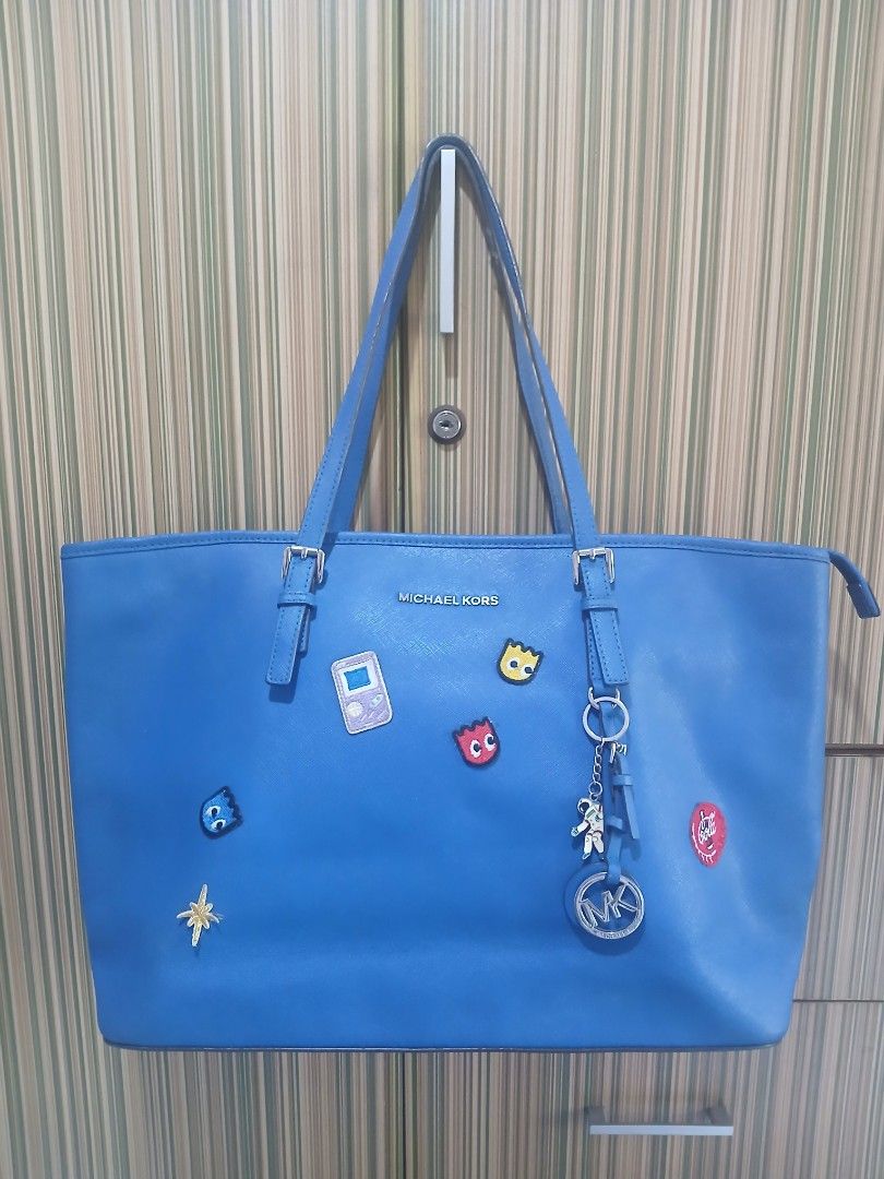 Michael Kors Blue Tote Bag with Charms (Category: Tote Bags) located in Taguig. Submitted by demsclosetph (Listing ID 1463616024, Image 1). Description: - Blue Michael Kors Tote Bag Large size - Adorable Pac-Man and Game Boy Charms Included - Secure Zipper Closure - Multiple Interior Pockets for Organization - Spacious Design, Perfect for Everyday Essentials.