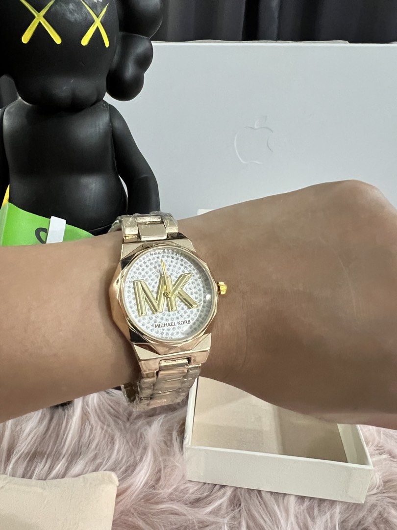 Michael Kors Gold MK Logo Watch (Category: Women's Watches) located in Calamba. Submitted by treghie.falcon (Listing ID 1463562098, Image 3). Description: - Gold Michael Kors Watch - Features the iconic MK logo on the face - Adorned with sparkly details around the dial - Includes original Michael Kors box - Versatile for both special events and daily wear Note: Pabenta po saakin. Super ganda sa personal. Mirror copy.