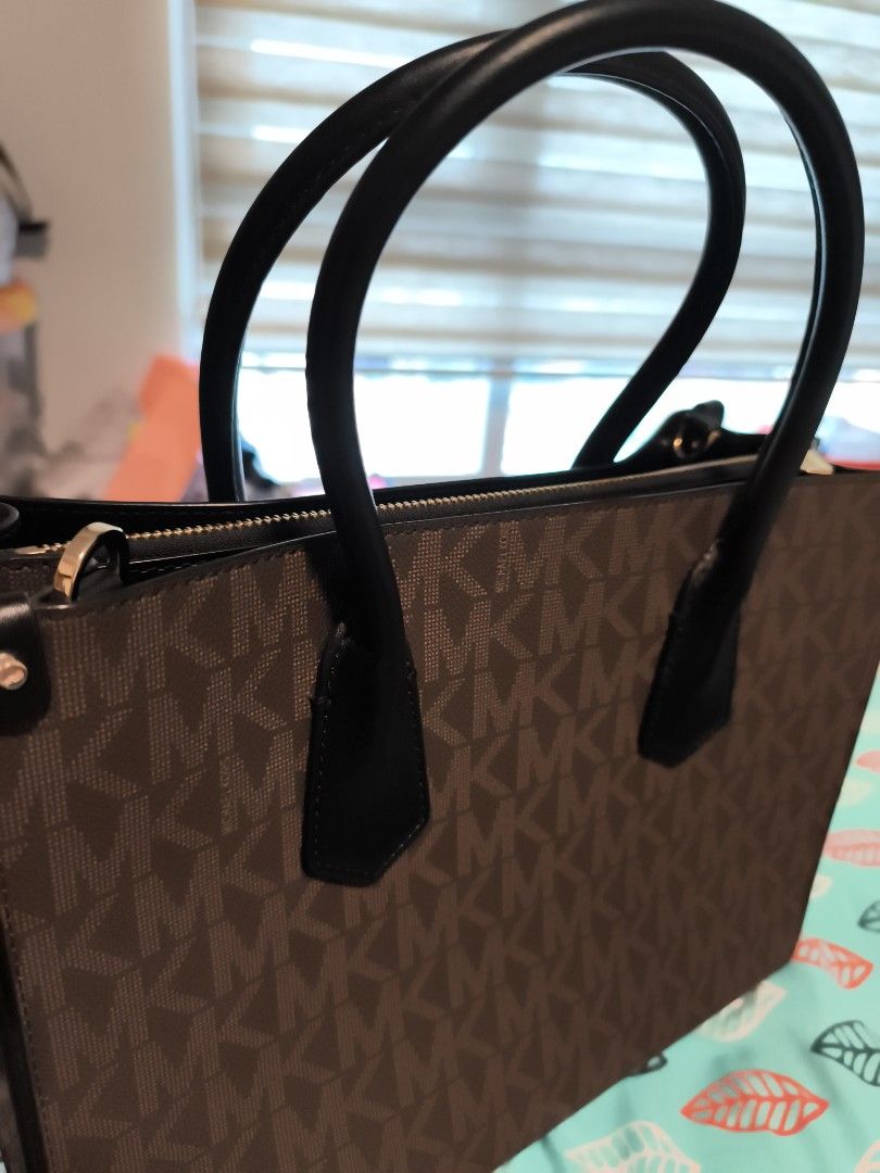 Michael Kors Monogram Tote Bag (Category: Luxury Bags & Wallets) located in Manila. Submitted by ma_ivee29 (Listing ID 1463637903, Image 3). Description: - Classic Michael Kors tote bag - Brown monogram print - Black leather handles and trim - Gold hardware details - Zipper closure for main compartment - Interior zippered pocket - Spacious for daily essentials - Stylish and practical everyday bag -with tag and good as new -original from USA.