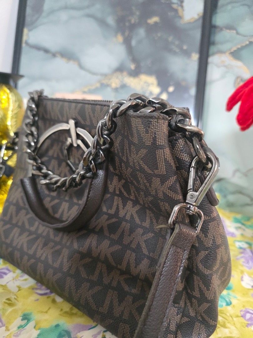 Michael Kors Monogrammed Shoulder Bag with Chain Strap (Category: Luxury Bags & Wallets) located in Binan City. Submitted by geraldinef58404 (Listing ID 1463653172, Image 2). Description: - Authentic Michael Kors bag - Signature MK monogram print - Color: Dark brown and tan - Features a stylish chain strap and a convenient top handle - Secure zipper closure - Interior with multiple compartments for organization - Ideal for everyday use.